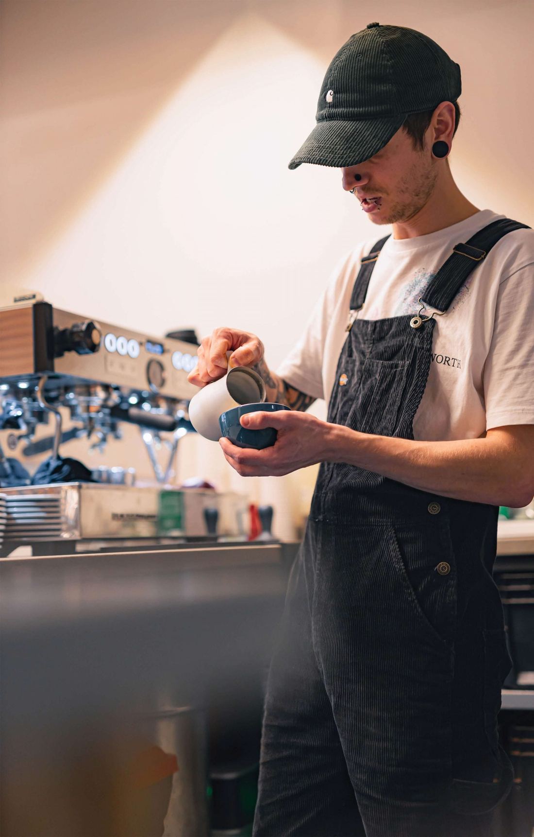 Barista spienia mleko przy Linei PB X